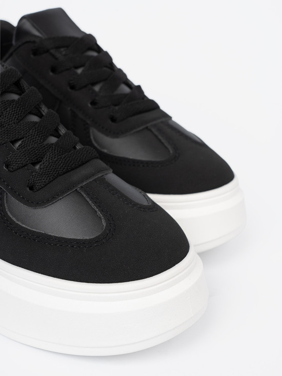 Klassische schwarze Sneakers mit dicker Sohle