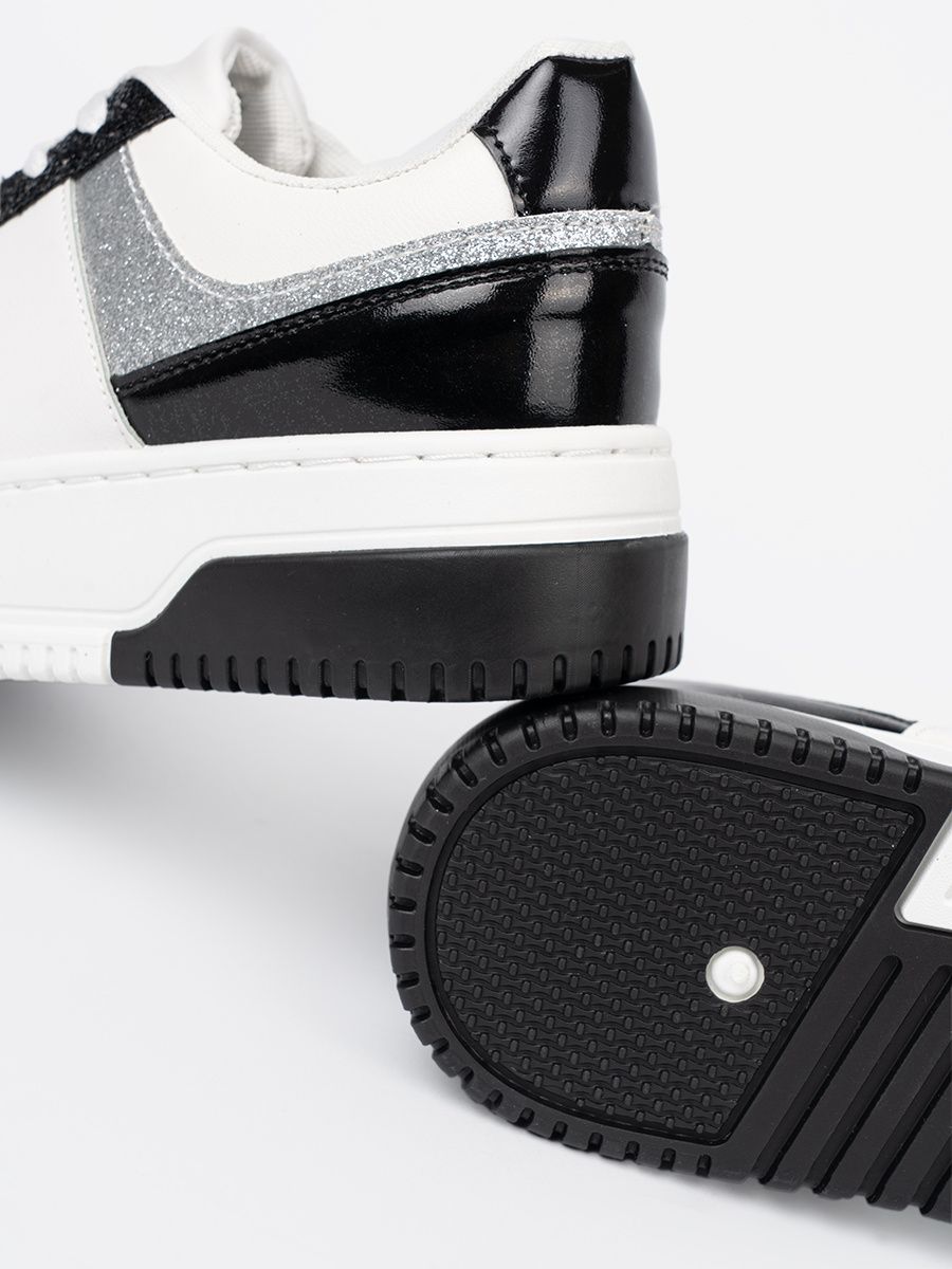 Schwarz-weiße Sneakers mit glänzenden silbernen Details