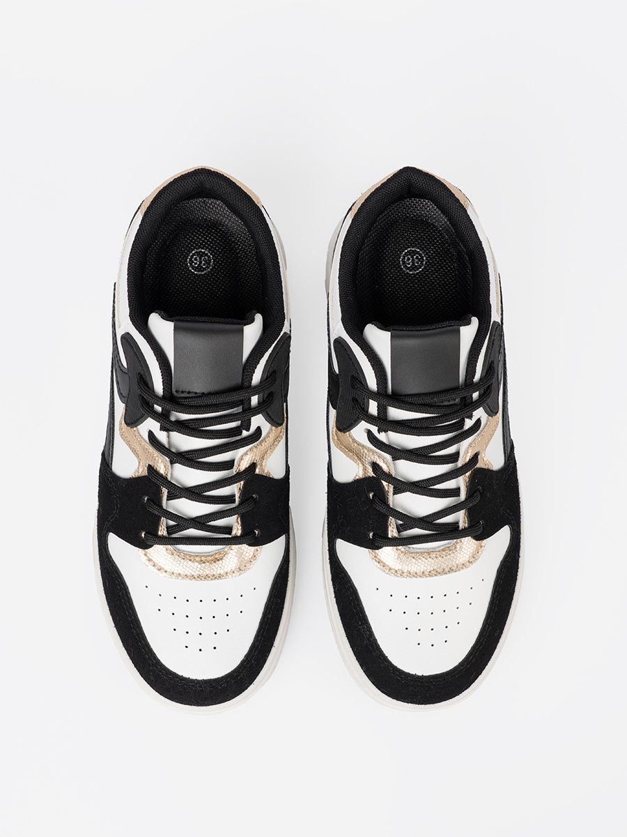 Schwarz-weiße Sneakers mit goldenen Details