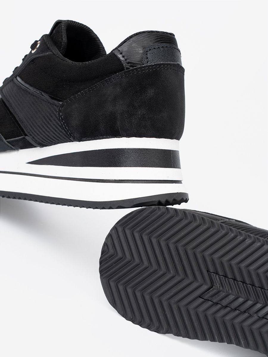 Moderne schwarze Sneakers mit glänzenden Details