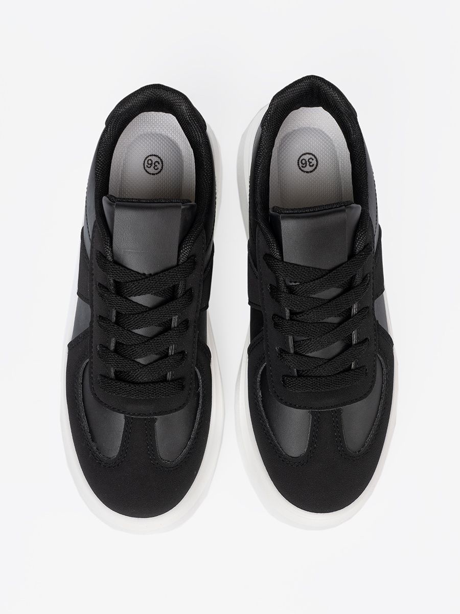Klassische schwarze Sneakers mit dicker Sohle