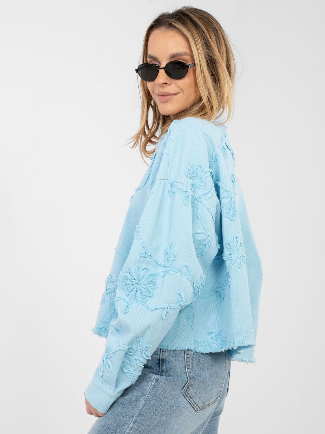 Kurze blaue Jeansjacke mit Blumenapplikation