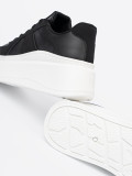 Klassische schwarze Sneakers mit dicker Sohle